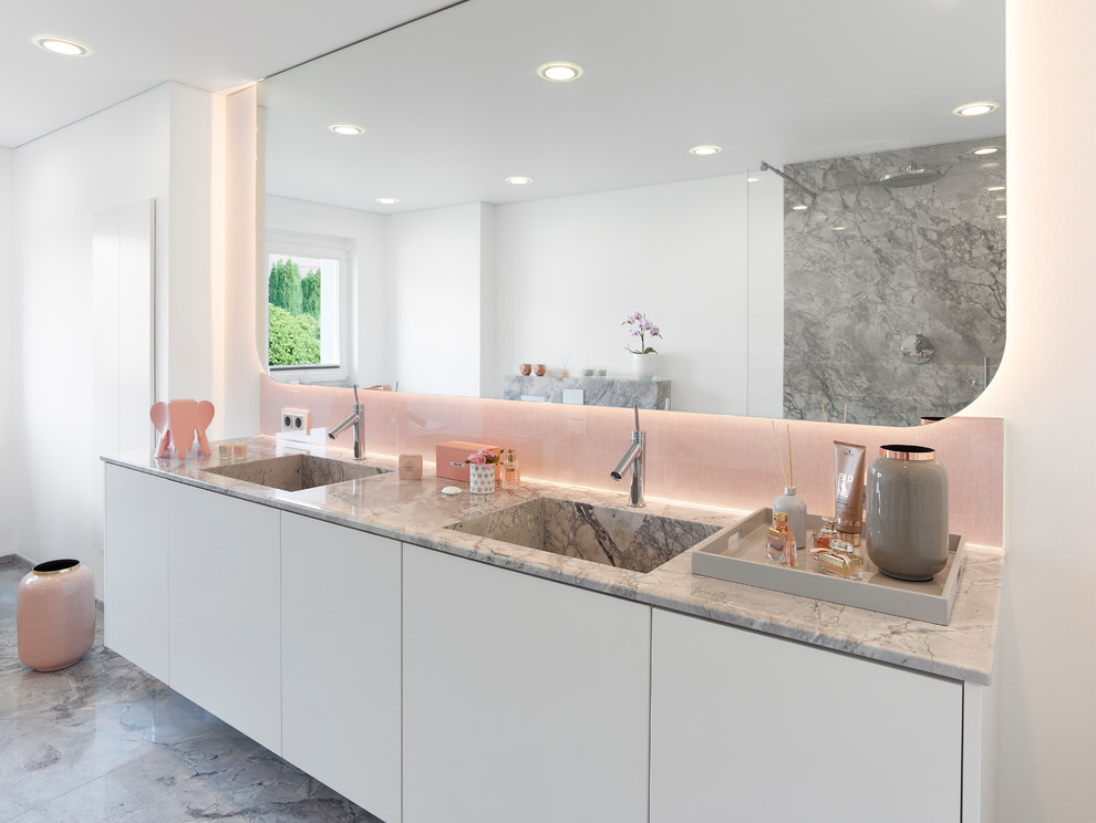 Photo of a mid-sized contemporary bathroom in Other with flat-panel cabinets, white cabinets, white walls, an integrated sink, grey floor, grey benchtops, marble floors and marble benchtops.