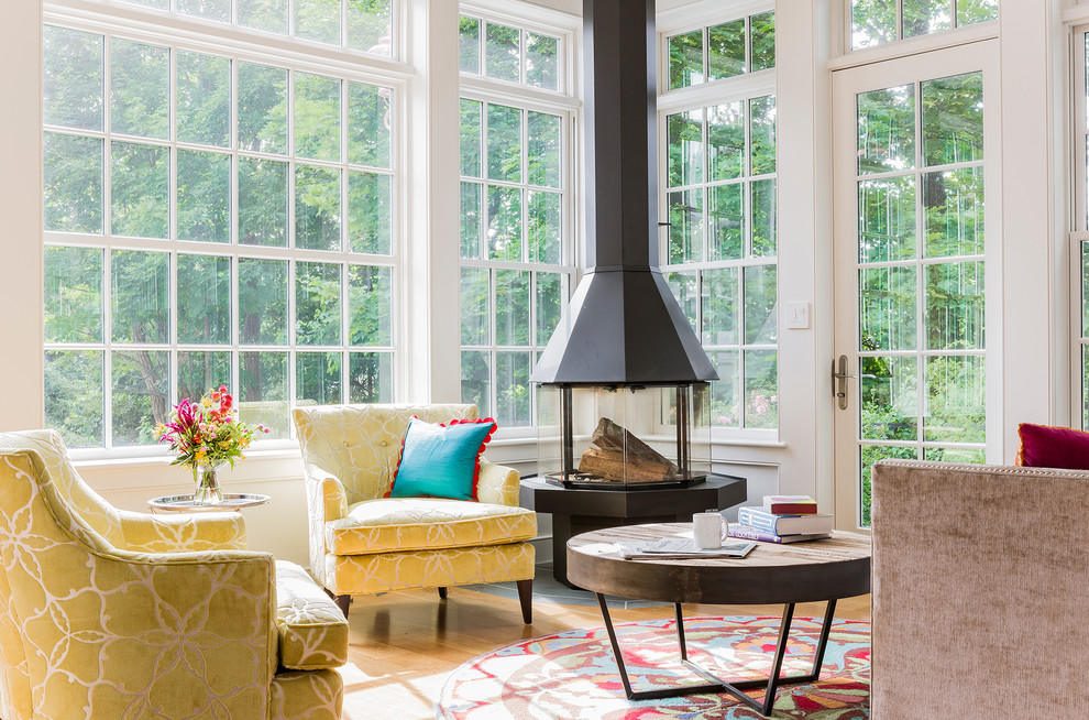 Inspiration for a mid-sized transitional sunroom in Boston with medium hardwood floors and a hanging fireplace.