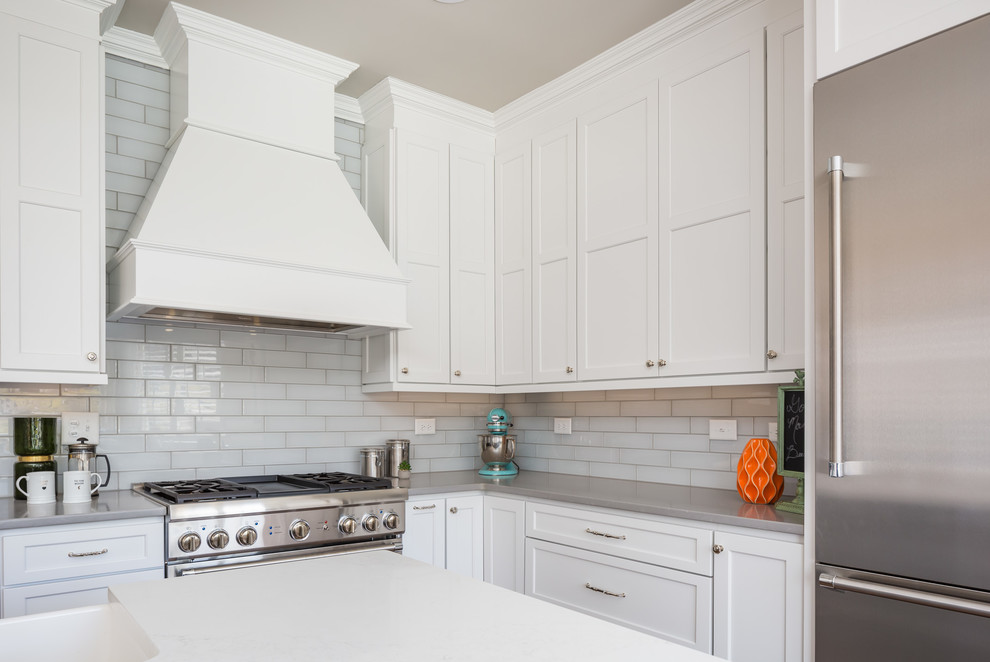 Open concept kitchen - huge transitional galley medium tone wood floor open concept kitchen idea in Raleigh with a farmhouse sink, flat-panel cabinets, white cabinets, quartz countertops, gray backsplash, ceramic backsplash, stainless steel appliances and two islands