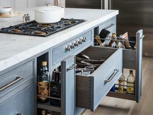 Open blue island drawers on soft-close slides beneath cooktop, showing level, parallel slide installation
