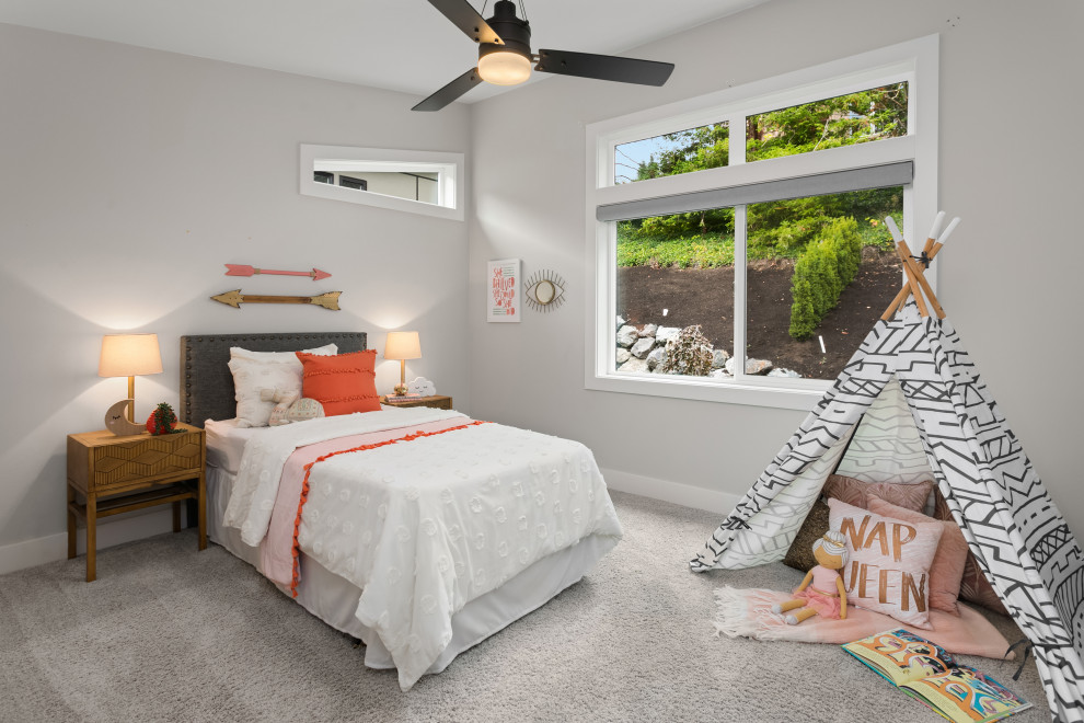 This is an example of a mid-sized transitional kids' bedroom for kids 4-10 years old and girls in Seattle with grey walls, carpet and grey floor.