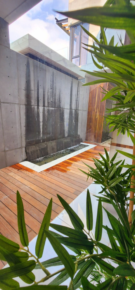 Идея дизайна: большой солнечный регулярный сад на склоне в современном стиле с водопадом, хорошей освещенностью и мощением клинкерной брусчаткой