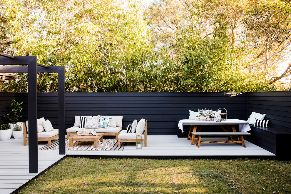 Mid-sized contemporary backyard deck in Sydney with a pergola.