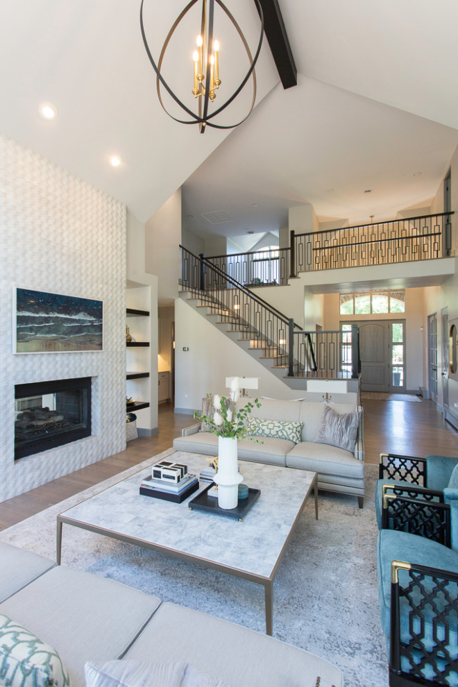 Large transitional formal open concept living room in Denver with white walls, light hardwood floors, a two-sided fireplace, a stone fireplace surround, a wall-mounted tv, brown floor and vaulted.