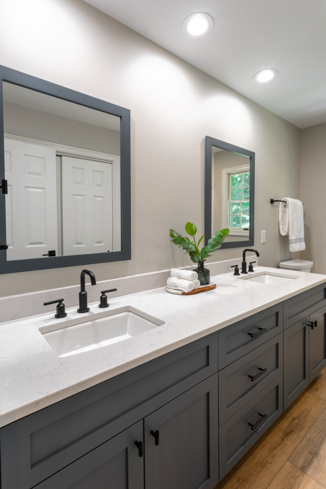 Photo of a mid-sized contemporary master bathroom in Cleveland with shaker cabinets, blue cabinets, an alcove shower, marble floors, an undermount sink, a hinged shower door, white benchtops, a double vanity and a built-in vanity.