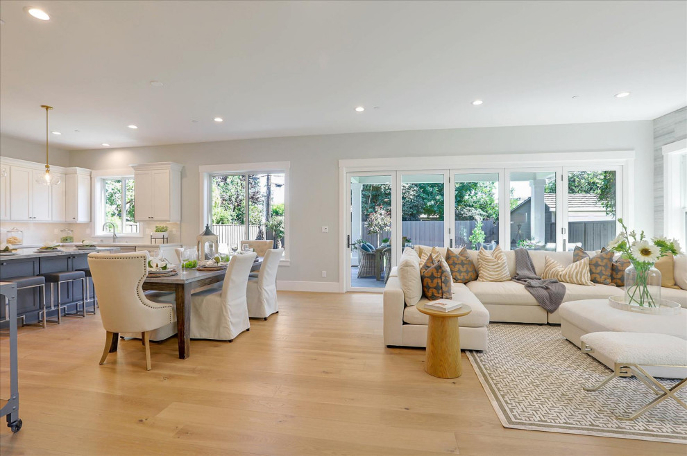 Example of a large beach style open concept light wood floor and brown floor family room design in San Francisco with gray walls, a standard fireplace and a stone fireplace