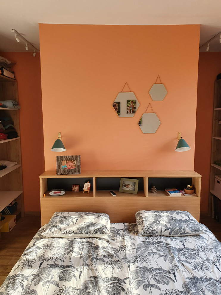 Bild på ett litet funkis huvudsovrum, med orange väggar, laminatgolv och brunt golv