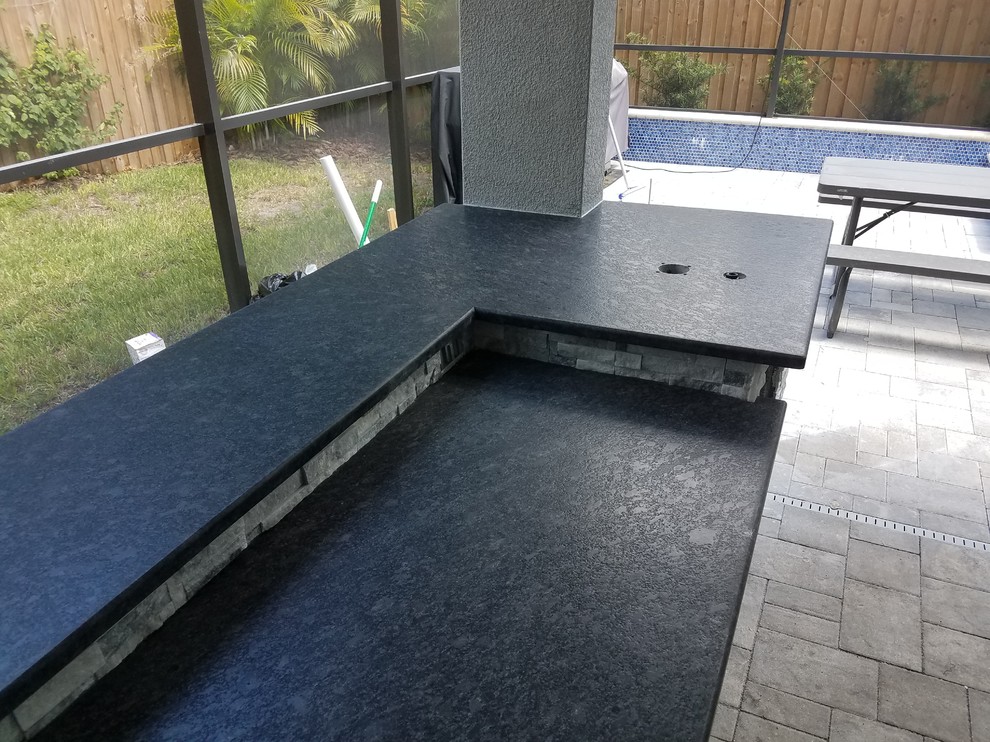 Inspiration for a mid-sized country backyard patio in Tampa with an outdoor kitchen, concrete pavers and a roof extension.