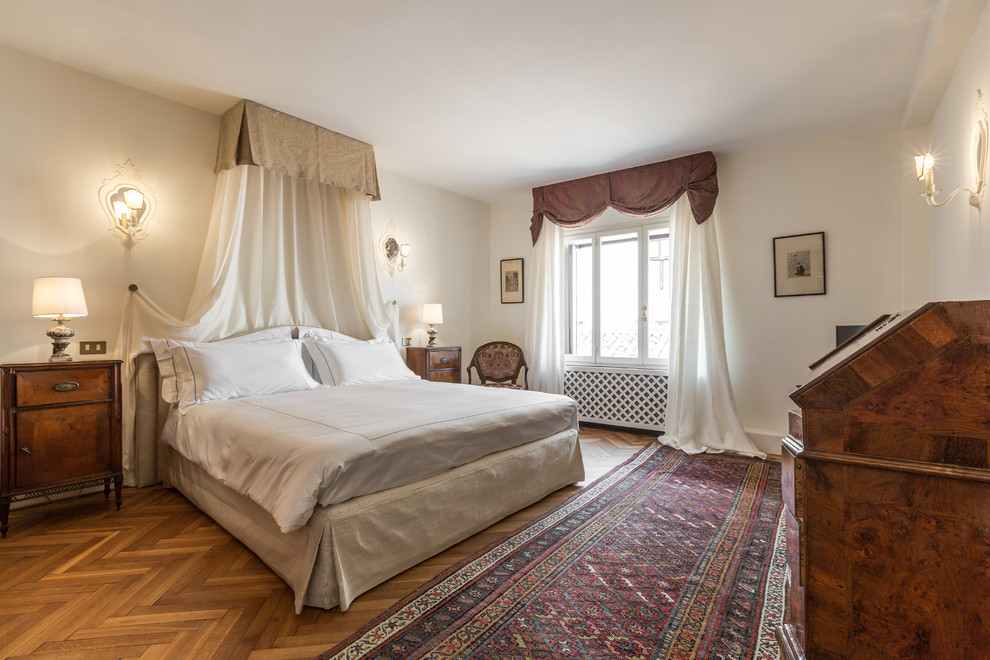 Inspiration for an expansive traditional master bedroom in Venice with white walls and medium hardwood floors.