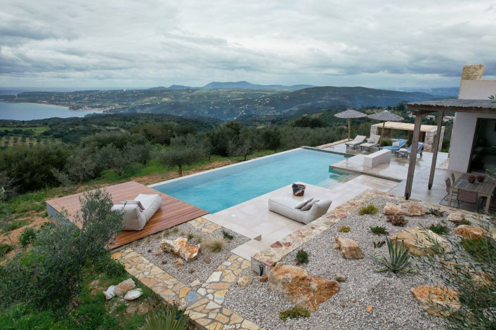 Diseño de casa de la piscina y piscina infinita tradicional renovada grande rectangular en patio con suelo de baldosas