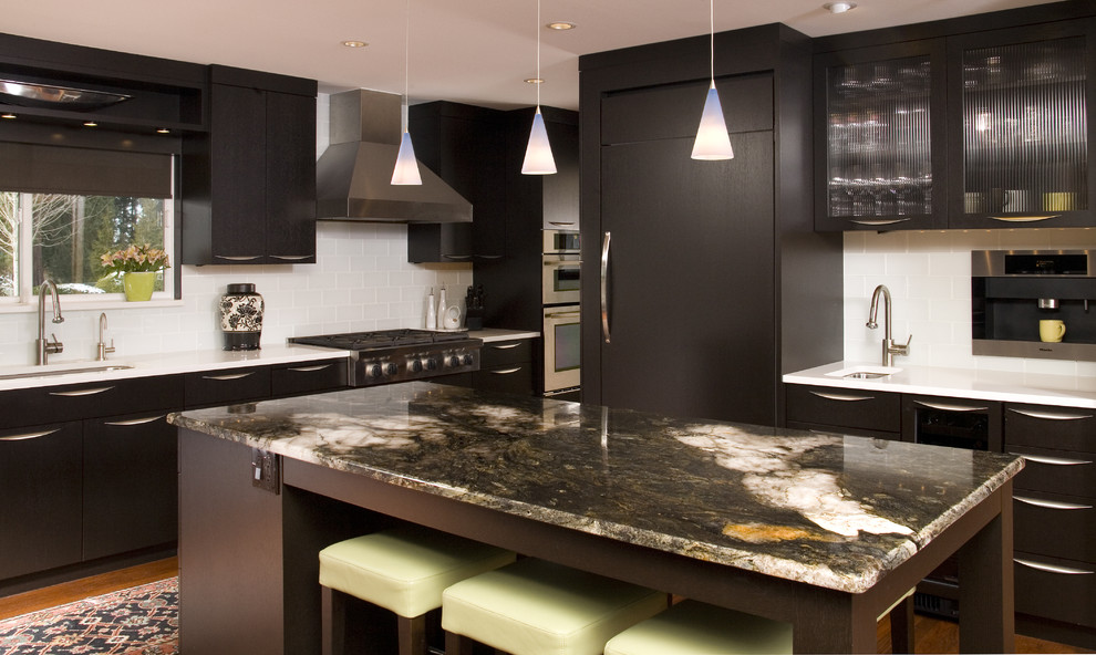 Photo of a contemporary kitchen in Seattle with glass tile splashback, white splashback, panelled appliances, an undermount sink, flat-panel cabinets and dark wood cabinets.