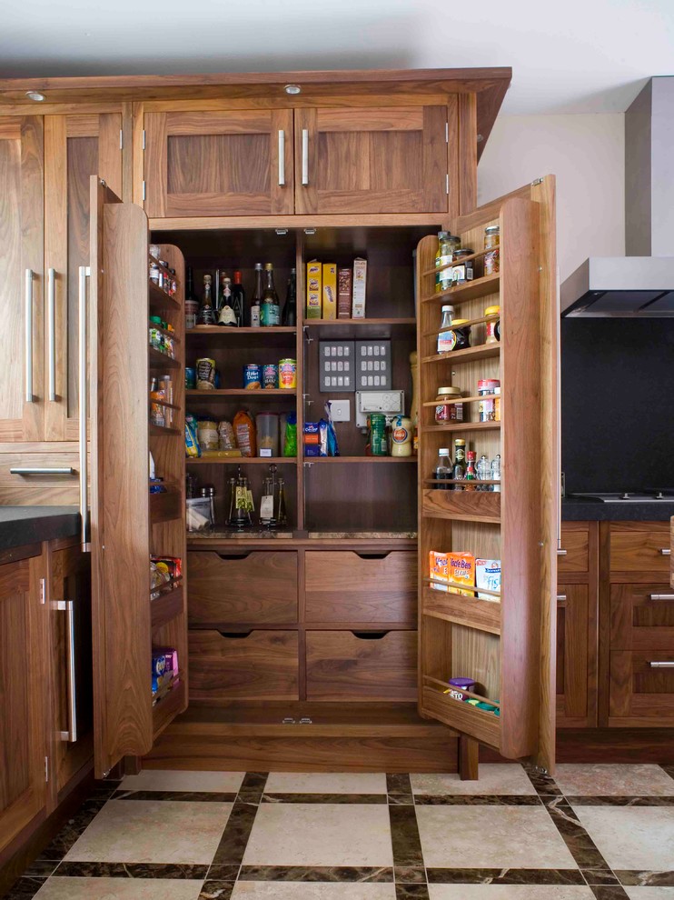 Photo of a transitional kitchen pantry in Essex with shaker cabinets and medium wood cabinets.