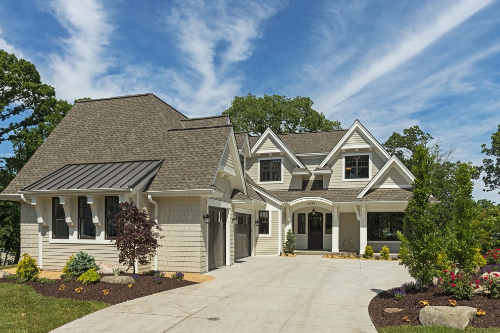 This is an example of a large beach style beige house exterior in Minneapolis with mixed siding, a gable roof and a shingle roof.