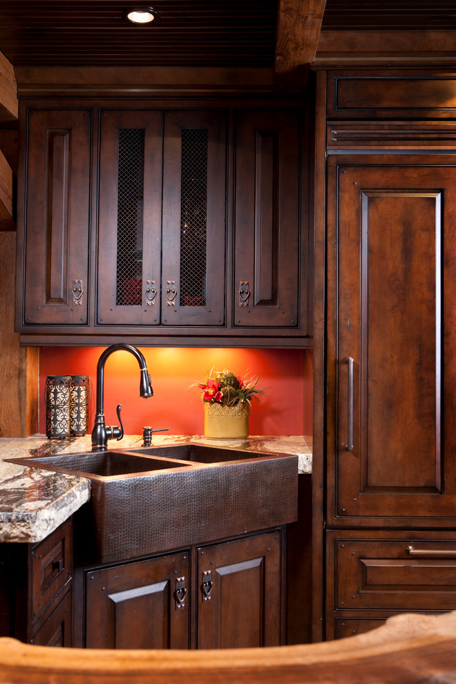 Example of a mid-sized mountain style u-shaped medium tone wood floor eat-in kitchen design in Toronto with raised-panel cabinets, distressed cabinets, granite countertops, paneled appliances and an island