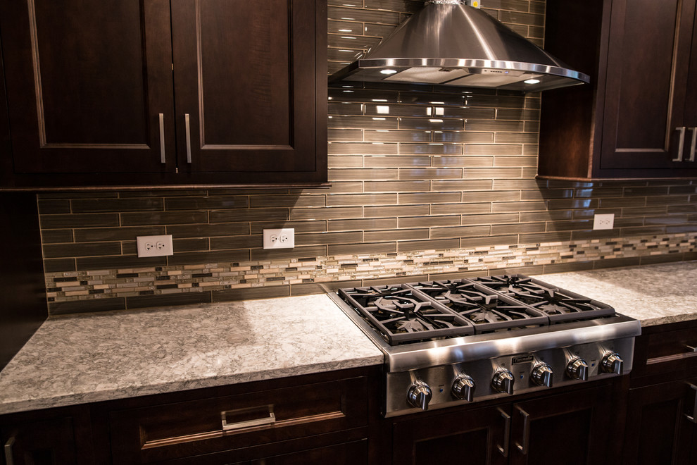 Eat-in kitchen - mid-sized transitional l-shaped dark wood floor eat-in kitchen idea in Chicago with an undermount sink, shaker cabinets, brown cabinets, granite countertops, gray backsplash, subway tile backsplash, stainless steel appliances and an island