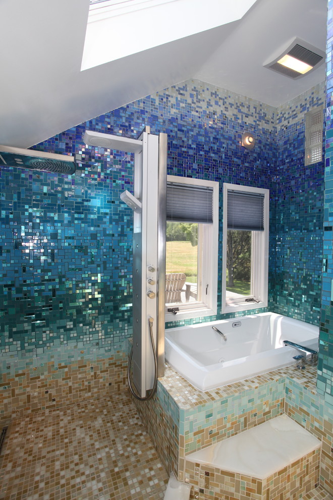 Inspiration for a large tropical master bathroom in New York with flat-panel cabinets, black cabinets, a drop-in tub, an open shower, a one-piece toilet, blue tile, glass tile, blue walls, ceramic floors, a pedestal sink, solid surface benchtops, beige floor and an open shower.