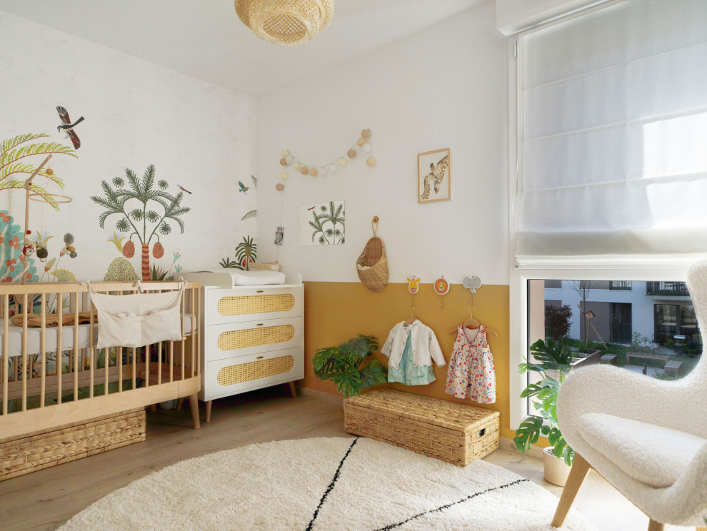 Стильный дизайн: нейтральная комната для малыша в скандинавском стиле с разноцветными стенами, светлым паркетным полом, бежевым полом и обоями на стенах - последний тренд