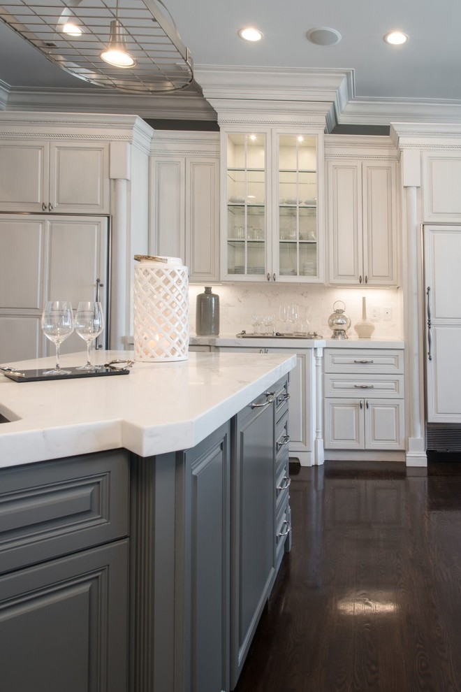 Design ideas for a large transitional u-shaped eat-in kitchen in St Louis with a farmhouse sink, raised-panel cabinets, white cabinets, white splashback, stone slab splashback, dark hardwood floors, with island, marble benchtops and panelled appliances.