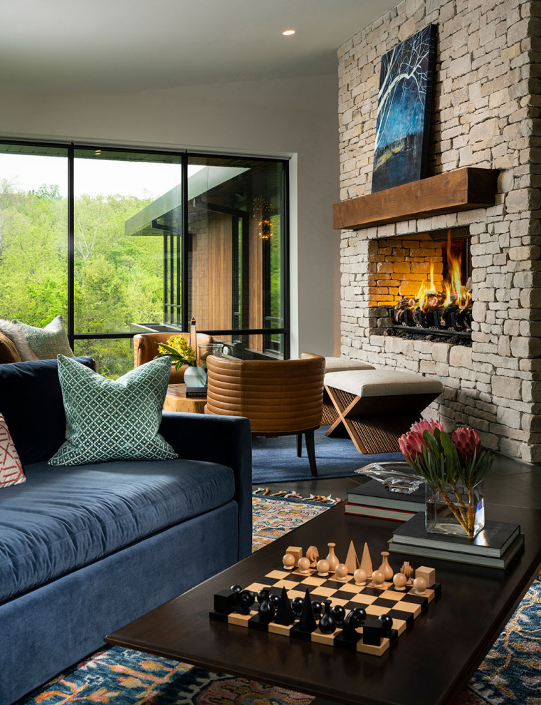 Inspiration for a large modern open concept ceramic tile, gray floor and vaulted ceiling living room remodel in Other with a two-sided fireplace and a stacked stone fireplace