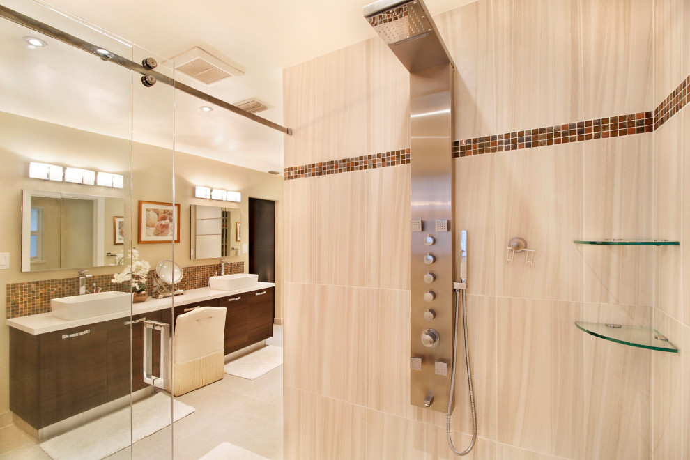 Photo of a large transitional master bathroom in Miami with flat-panel cabinets, medium wood cabinets, a freestanding tub, an alcove shower, stone tile, beige walls, a vessel sink, engineered quartz benchtops, beige floor, a sliding shower screen, white benchtops, a double vanity, a built-in vanity, a one-piece toilet, beige tile and limestone floors.