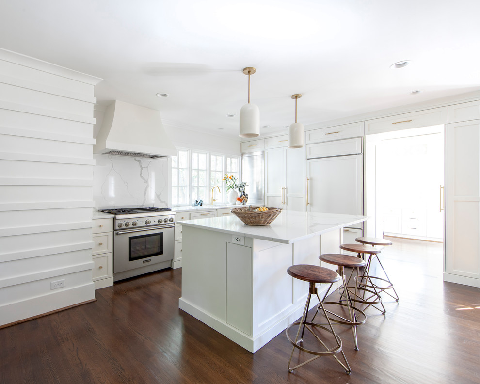 Kitchen - transitional l-shaped dark wood floor and brown floor kitchen idea in Charlotte with an undermount sink, recessed-panel cabinets, white cabinets, white backsplash, stone slab backsplash, paneled appliances, an island and white countertops