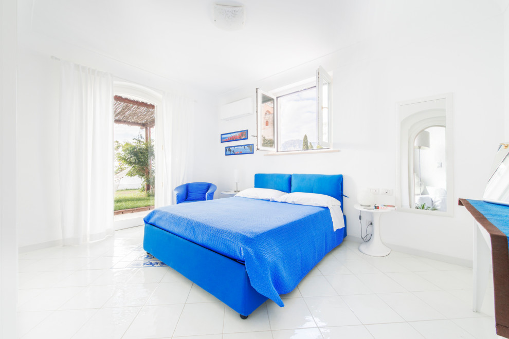 Пример оригинального дизайна: хозяйская спальня среднего размера в средиземноморском стиле с белыми стенами, полом из керамогранита и белым полом