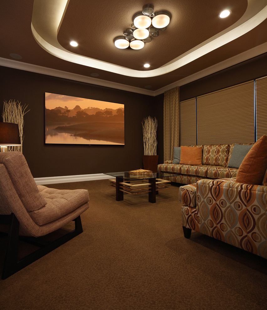 This is an example of a traditional open concept home theatre in Orlando with brown walls, carpet, a projector screen and beige floor.