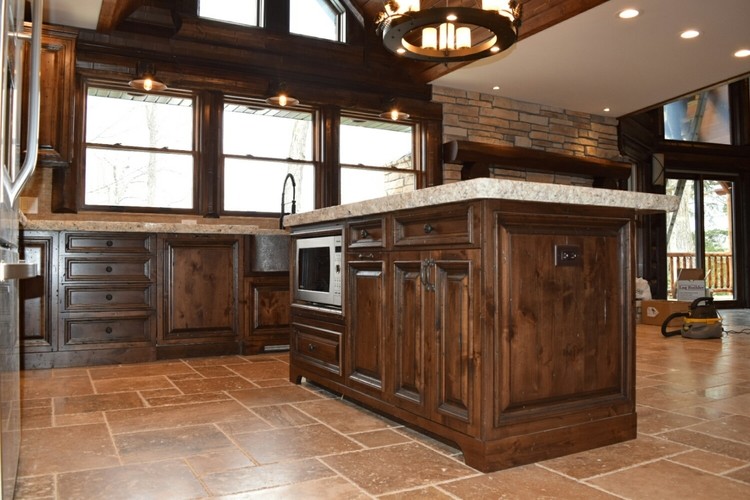Enclosed kitchen - mid-sized rustic l-shaped travertine floor and brown floor enclosed kitchen idea in Chicago with a farmhouse sink, raised-panel cabinets, dark wood cabinets, granite countertops, stainless steel appliances, an island and white countertops