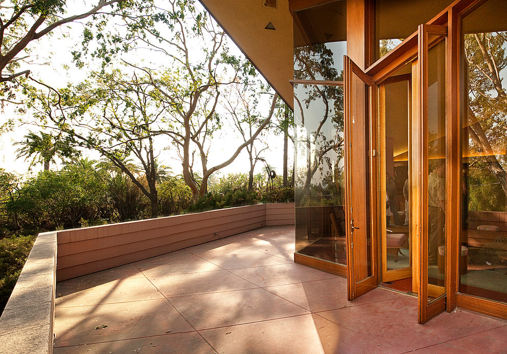 This is an example of a contemporary patio in Los Angeles with a roof extension.