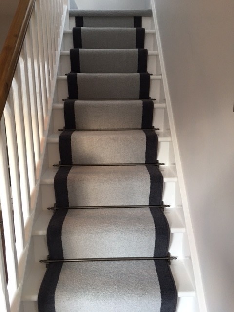 This is an example of a traditional carpeted straight staircase in Hampshire with carpet risers.