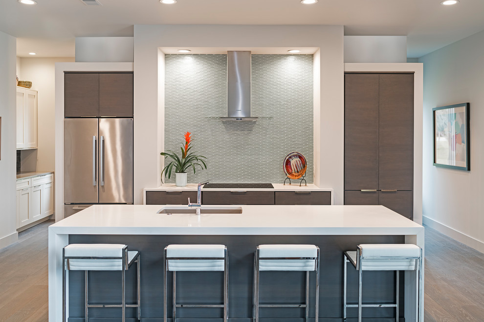 This is an example of an expansive contemporary galley kitchen in Atlanta with an undermount sink, flat-panel cabinets, dark wood cabinets, quartz benchtops, grey splashback, glass tile splashback, stainless steel appliances, dark hardwood floors, with island and brown floor.