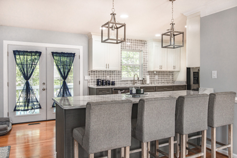 Large contemporary galley eat-in kitchen in DC Metro with an undermount sink, shaker cabinets, dark wood cabinets, marble benchtops, white splashback, stainless steel appliances, laminate floors, a peninsula, multi-coloured floor and white benchtop.