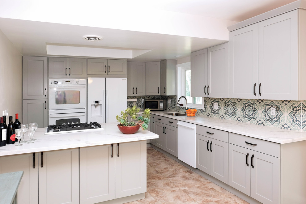 Photo of a small traditional l-shaped eat-in kitchen in Los Angeles with a drop-in sink, shaker cabinets, grey cabinets, quartz benchtops, blue splashback, cement tile splashback, white appliances, ceramic floors, no island and pink floor.