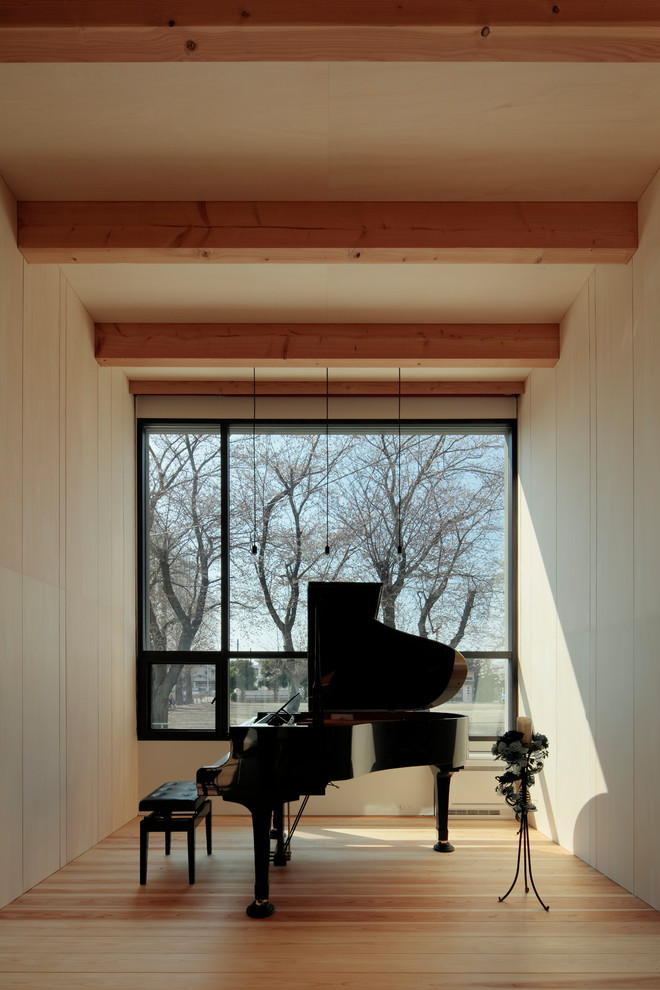 Photo of a modern home studio in Tokyo with beige walls, light hardwood floors and beige floor.