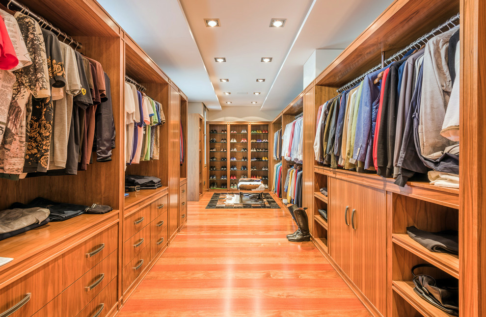 Inspiration for an expansive transitional men's walk-in wardrobe in Malaga with open cabinets, medium wood cabinets, orange floor and medium hardwood floors.