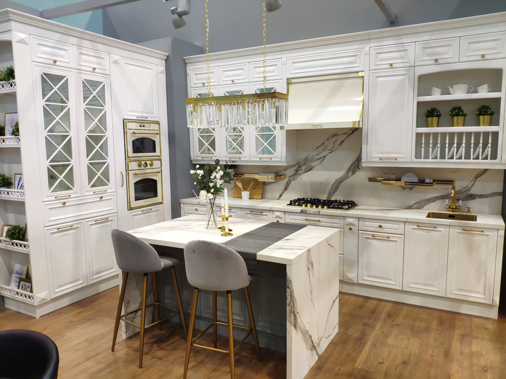 Photo of a large traditional l-shaped eat-in kitchen in Moscow with an undermount sink, beaded inset cabinets, white cabinets, marble benchtops, multi-coloured splashback, marble splashback, white appliances, laminate floors, with island, brown floor and multi-coloured benchtop.
