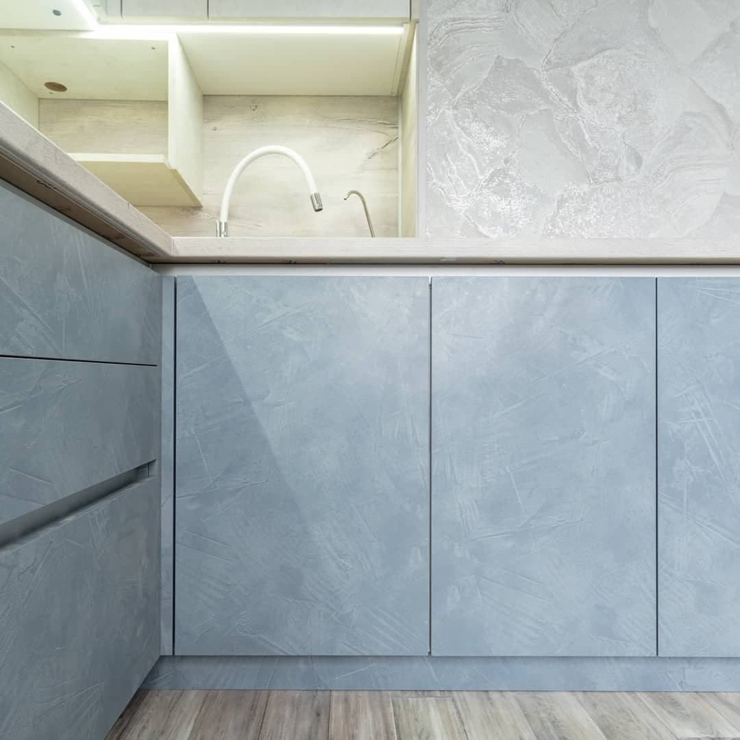 Большая угловая кухня в синем и белом цвете с фасадами под камень