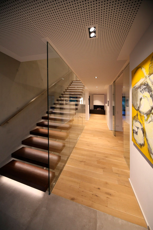Cette photo montre un escalier droit moderne avec des marches en bois et un garde-corps en verre.