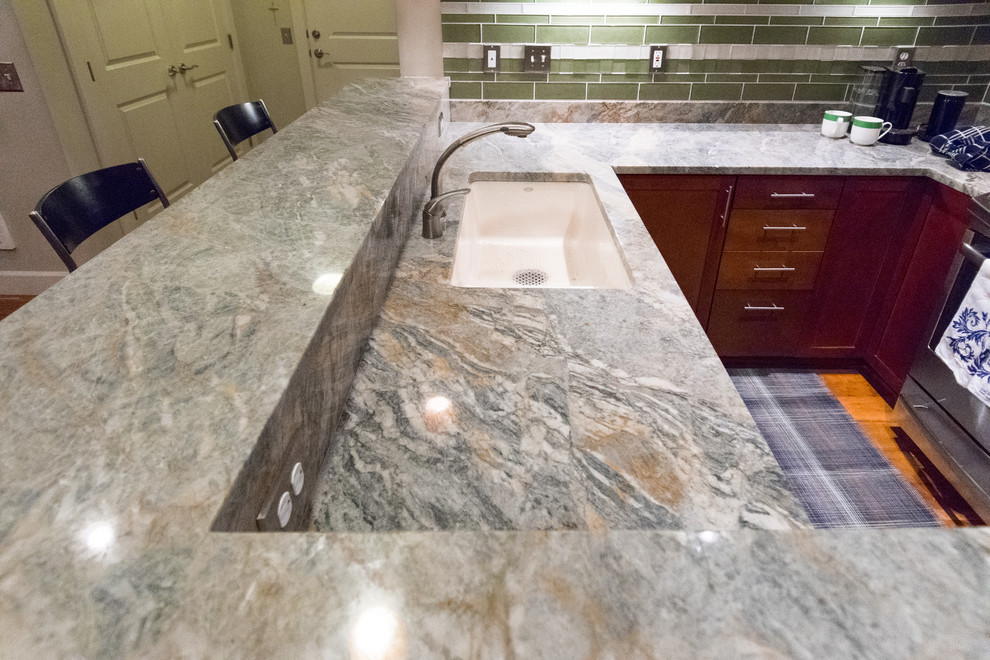 Example of a transitional kitchen design with an undermount sink, granite countertops, green backsplash, stone slab backsplash and stainless steel appliances