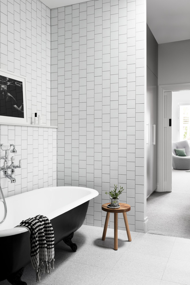 Contemporary master bathroom in Melbourne with flat-panel cabinets, black cabinets, a claw-foot tub, a corner shower, a wall-mount toilet, white tile, ceramic tile, white walls, marble floors, a console sink, engineered quartz benchtops, grey floor, a hinged shower door and white benchtops.