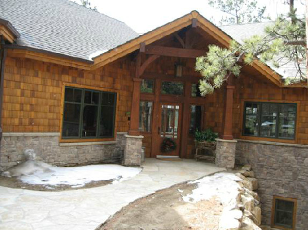 This is an example of a large arts and crafts two-storey multi-coloured exterior in Denver with mixed siding and a clipped gable roof.