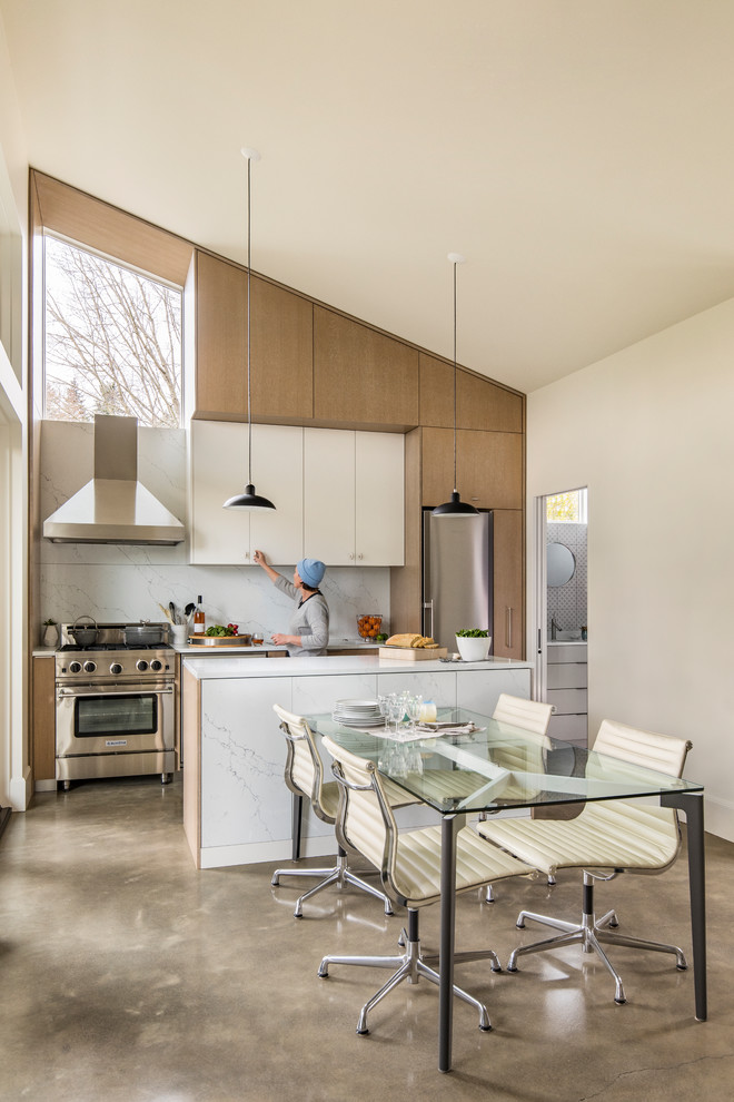 This is an example of a small modern open plan dining in Portland with white walls and concrete floors.