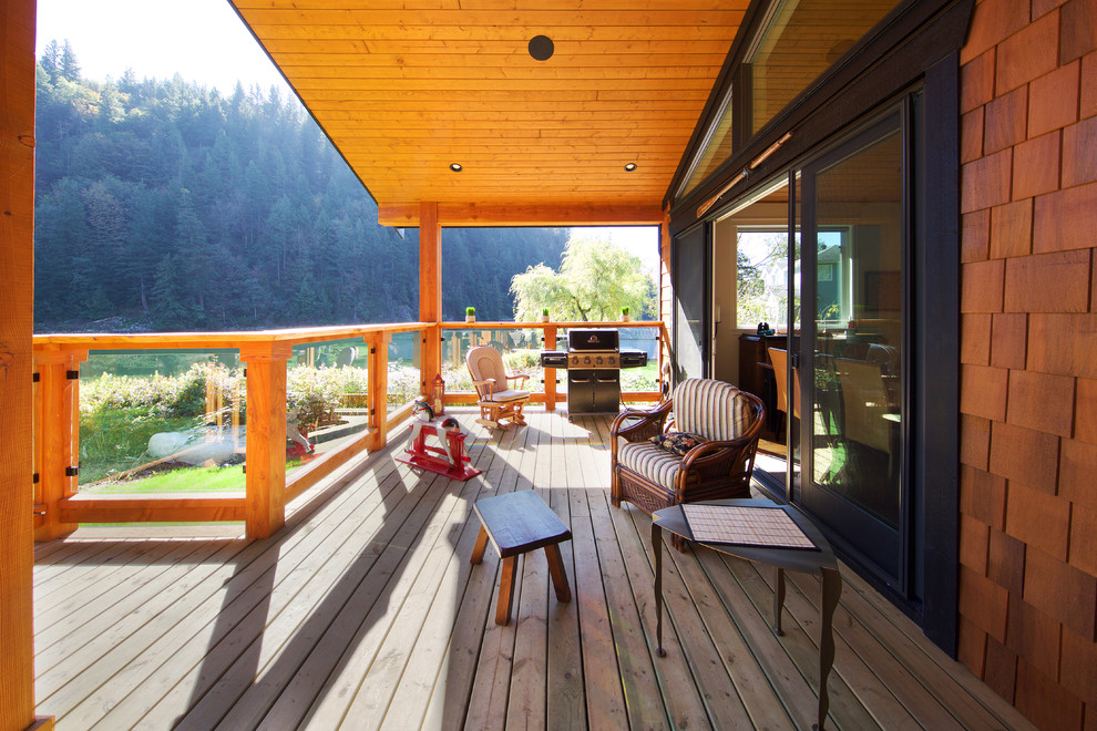 Inspiration for a mid-sized rustic backyard water fountain deck remodel in Vancouver with a roof extension
