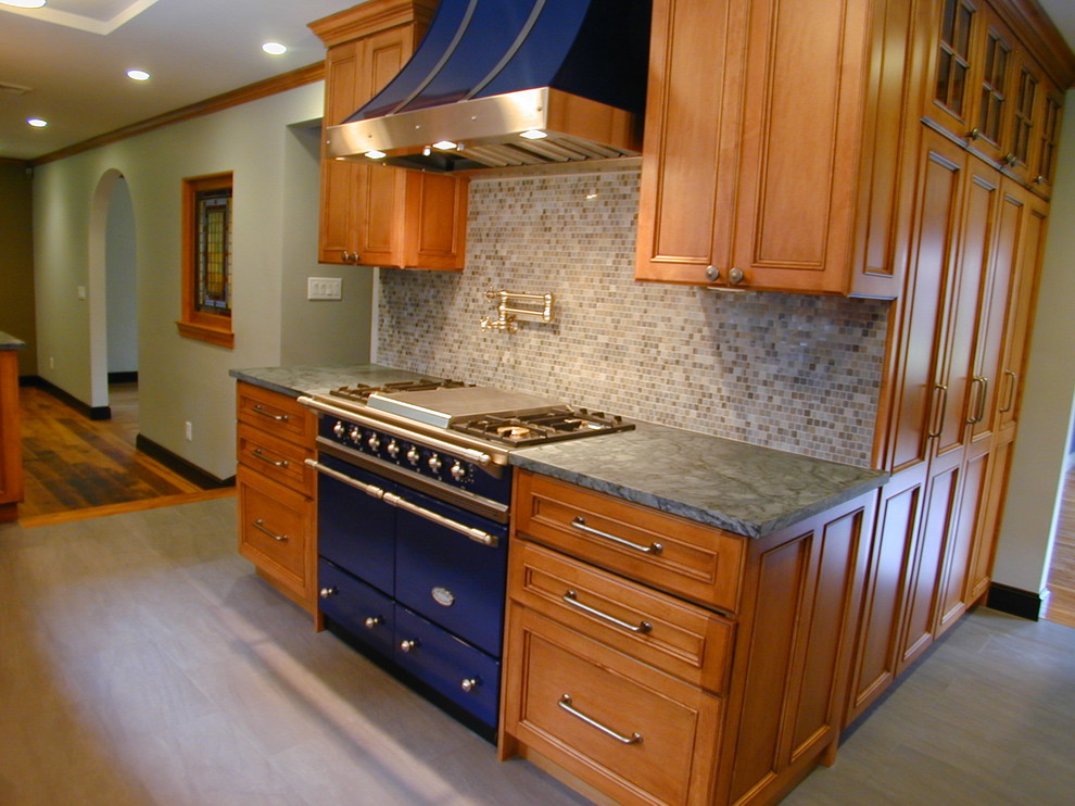 Eat-in kitchen - large transitional u-shaped porcelain tile eat-in kitchen idea in Boston with a farmhouse sink, recessed-panel cabinets, dark wood cabinets, soapstone countertops, white backsplash, mosaic tile backsplash, stainless steel appliances and an island