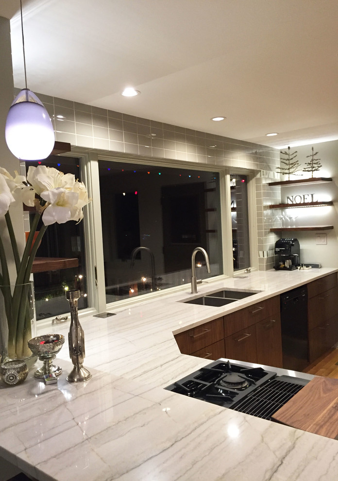 This is an example of a contemporary l-shaped kitchen in Seattle with an undermount sink, flat-panel cabinets, dark wood cabinets, granite benchtops, grey splashback, porcelain splashback and a peninsula.