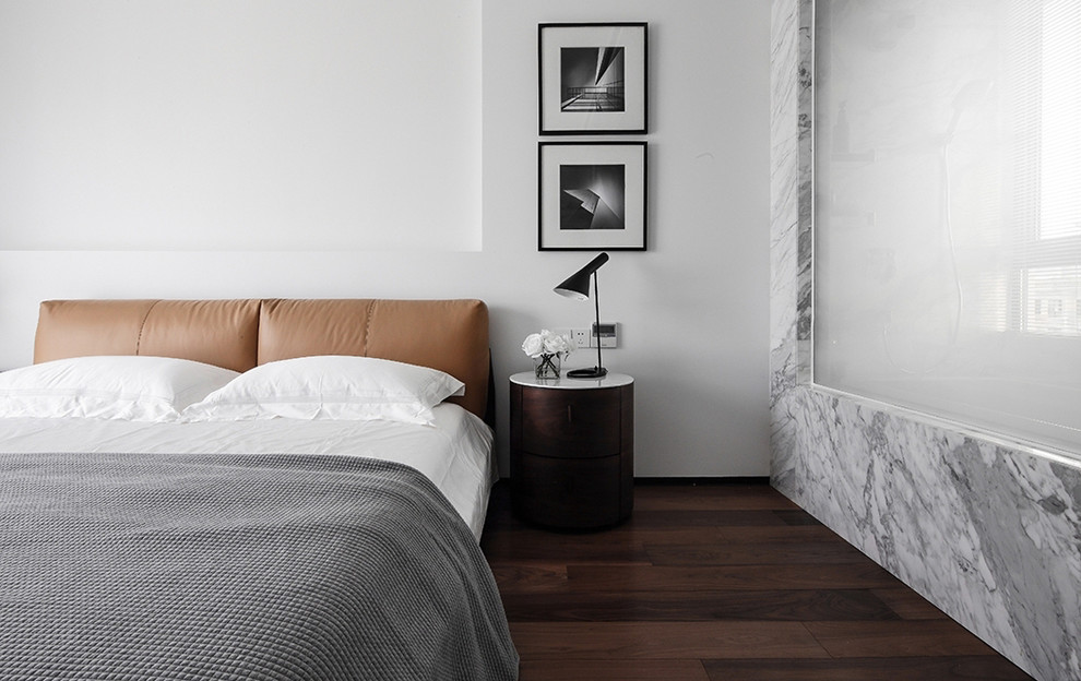 Photo of a contemporary bedroom in Other with white walls, dark hardwood floors and brown floor.