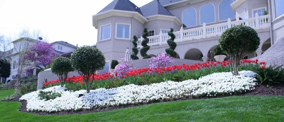 Photo of a mid-sized full sun backyard retaining wall landscape.