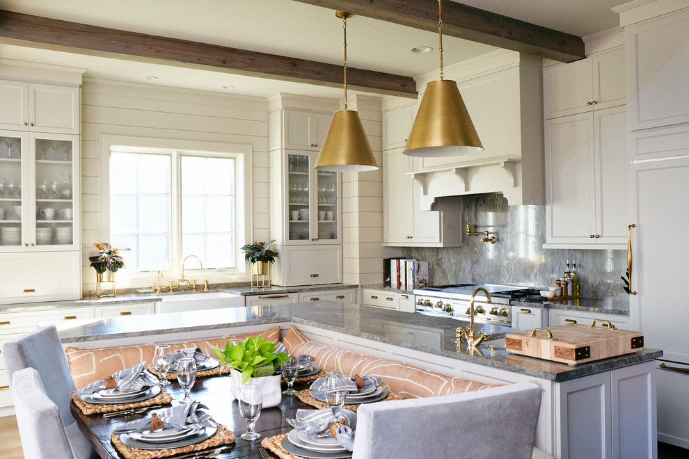 Example of a large transitional l-shaped medium tone wood floor and brown floor eat-in kitchen design with a farmhouse sink, raised-panel cabinets, white cabinets, marble countertops, gray backsplash, marble backsplash, stainless steel appliances, an island and gray countertops