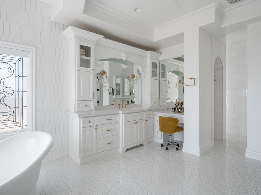 На фото: большая главная ванная комната с фасадами с выступающей филенкой, белыми фасадами, отдельно стоящей ванной, открытым душем, унитазом-моноблоком, белой плиткой, керамической плиткой, белыми стенами, полом из керамогранита, врезной раковиной, столешницей из искусственного кварца, белым полом, открытым душем, белой столешницей, сиденьем для душа, тумбой под две раковины, встроенной тумбой, любым потолком и любой отделкой стен