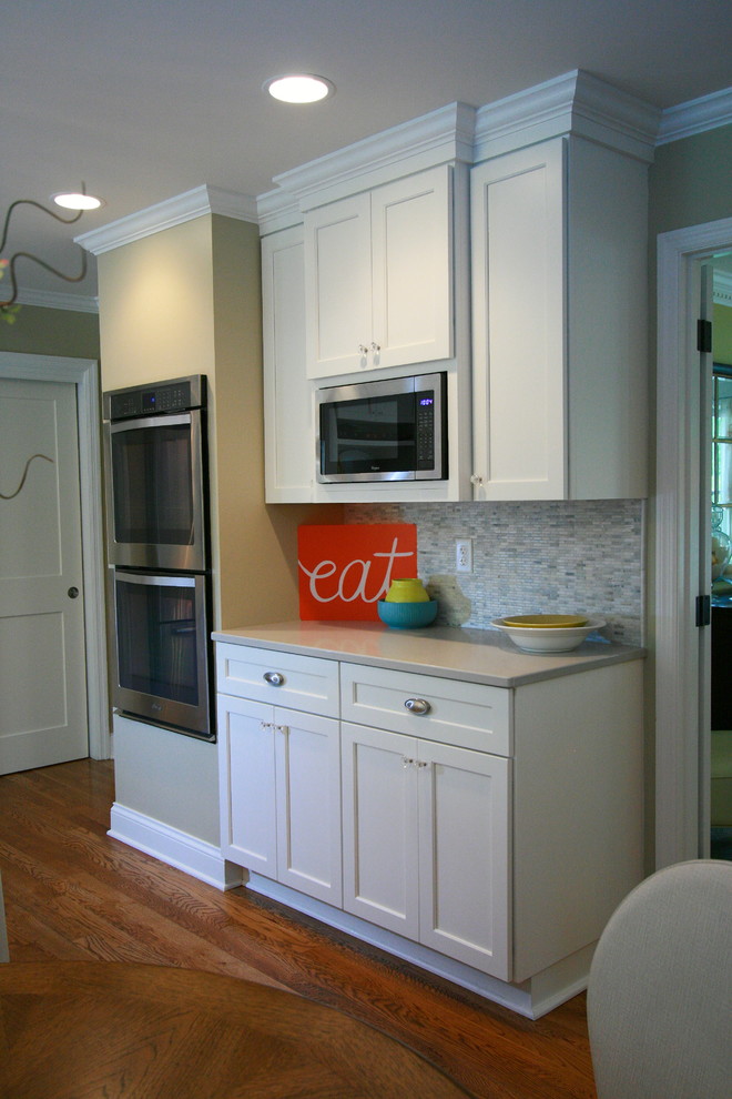 Example of a large transitional medium tone wood floor kitchen design in Cincinnati with a double-bowl sink, shaker cabinets, white cabinets, quartz countertops, gray backsplash, porcelain backsplash, stainless steel appliances and an island